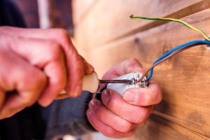 Hands of unrecognizable electrician working with screwdriver